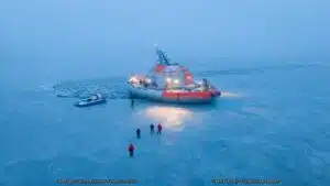 A gray and orange scientific station on blue ice